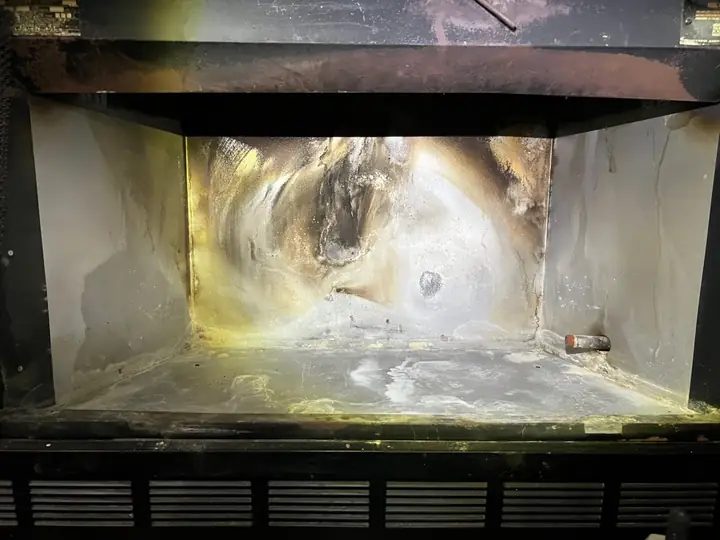 Burned-through panels inside a factory-built wood fireplace