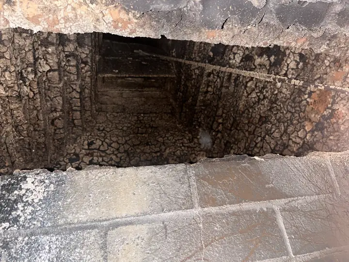 Rough, stepped brick and soot above a fireplace damper