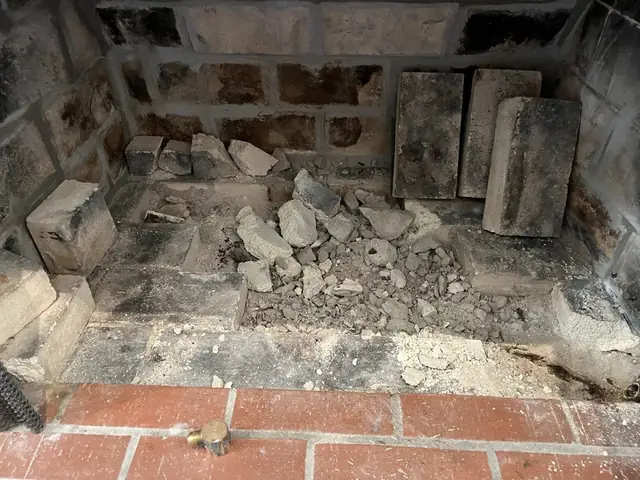 Broken firebrick fallen onto a fireplace floor