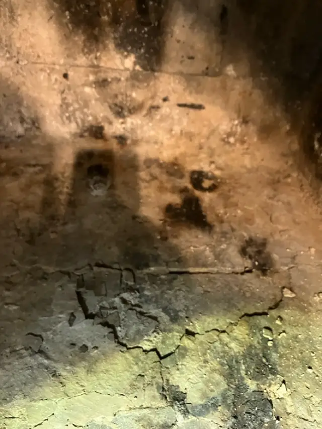 Cracked firebrick in the floor and back of a fireplace