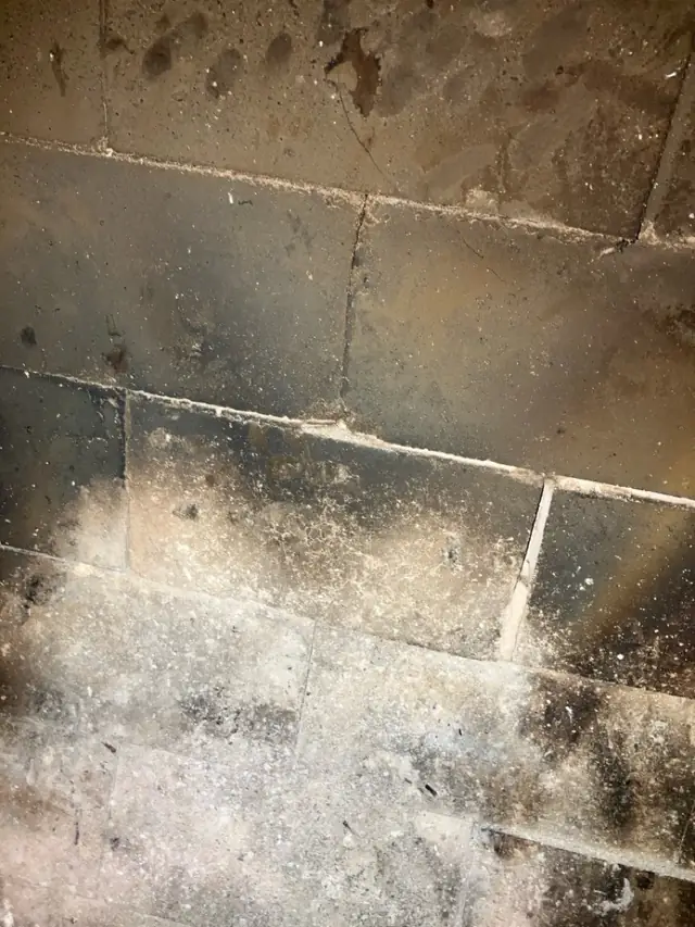 Firebox back wall with worn, crumbling mortar joints