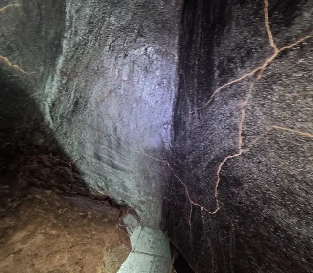 Cracked, soot-covered smoke chamber above a fireplace