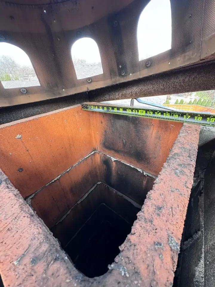 Looking down a rusted chimney flue before a new damper